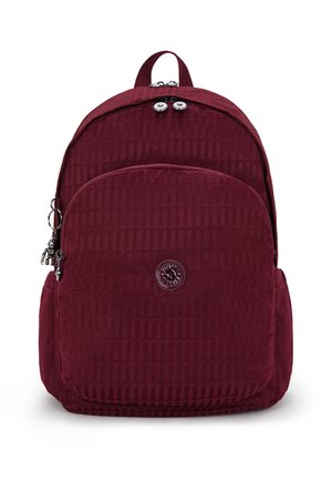 Burgundy backpack with quilted texture, top handle, and zipper pocket. Features logo patch and small hardware accents.
