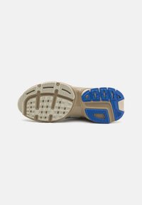 Shoe sole featuring a beige rubber base with textured white and blue tread patterns; designed for traction and durability.