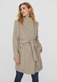 Beige, bälte coat med hög krage, tillverkad av texturerad tyg, med dragkedjeförsedda sidofickor och skräddarsydd passform, knälång design.