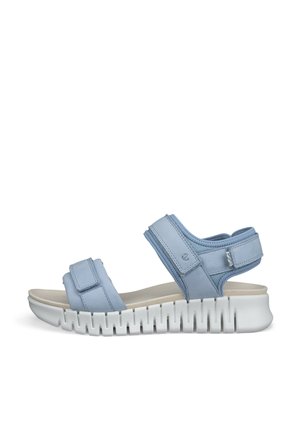 Svetlomodrá otvorená sandála s nastaviteľnými remienkami a hrubou bielou podrážkou s drážkami, navrhnutá pre pohodlie a bežné nosenie.