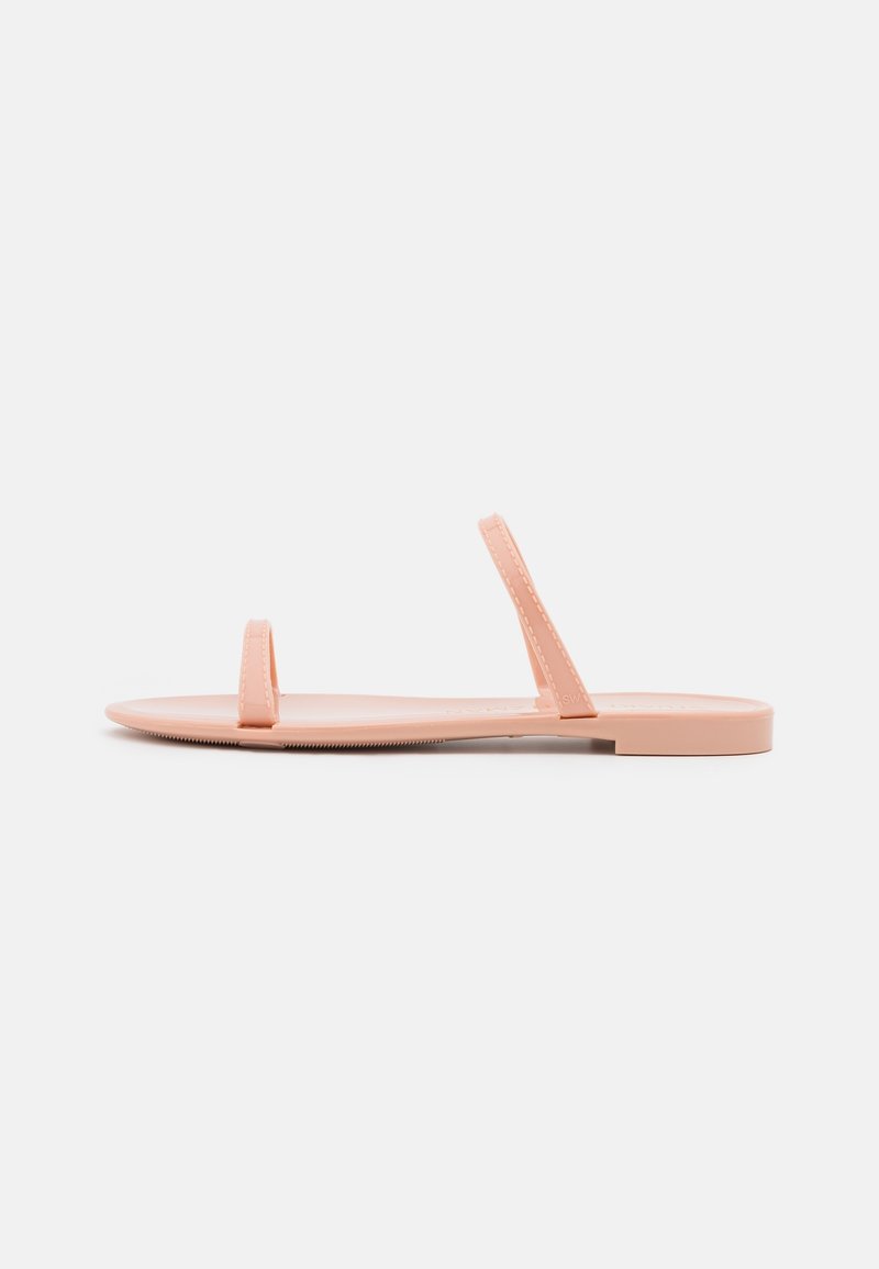 Tongs plates en caoutchouc doux pêche, dotées de deux fines lanières, d'une semelle intérieure texturée et d'une semelle extérieure lisse pour le confort.