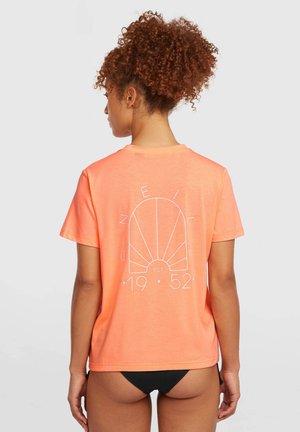 Koralowy t-shirt z krótkim rękawem wykonany z miękkiej tkaniny, z grafiką białej muszli i napisem na plecach, o luźnym kroju i okrągłym dekolcie.