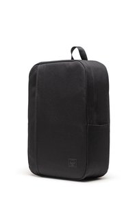Schwarzer Rucksack aus strukturiertem Stoff, rechteckig geformt, mit einer Seitentasche und einem Obertragegriff. Mit einem Logopatch.