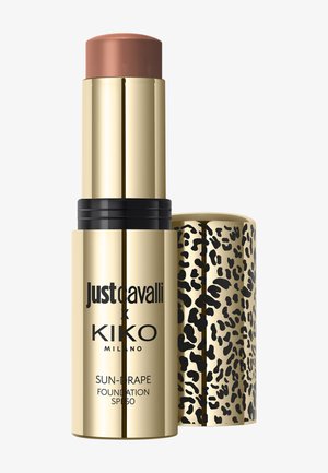Stick fond de teint doré avec embout crème marron, texte noir "Just Cavalli x KIKO Milano" et bouchon imprimé léopard, étiqueté SPF 50.