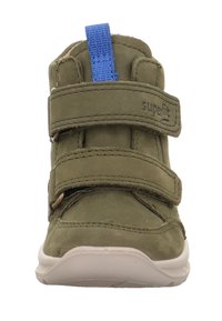 Dětská obuv olivově zelené barvy s kulatou špičkou, dvěma suchými zipy a modrým poutkem na kotníku. Má gumovou podrážku a prošívané detaily.