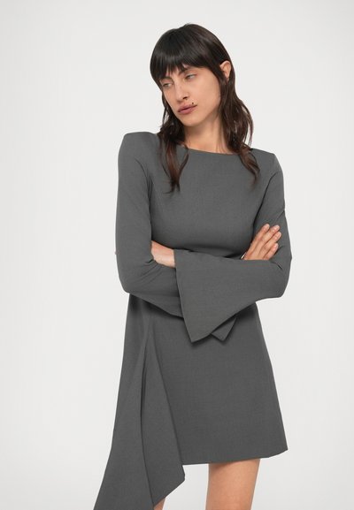 Szürke harangujjú ruha négyzet alakú nyakkivágással és aszimmetrikus szegéllyel. Egyenletes szövetből készült, letisztult sziluettel és minimális részletezéssel.