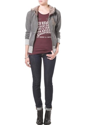 Sudadera gris con cremallera y un interior texturizado, camiseta gráfica burdeos, jeans de un azul oscuro y botas negras de tobillo. Diseño simple y forma ajustada.