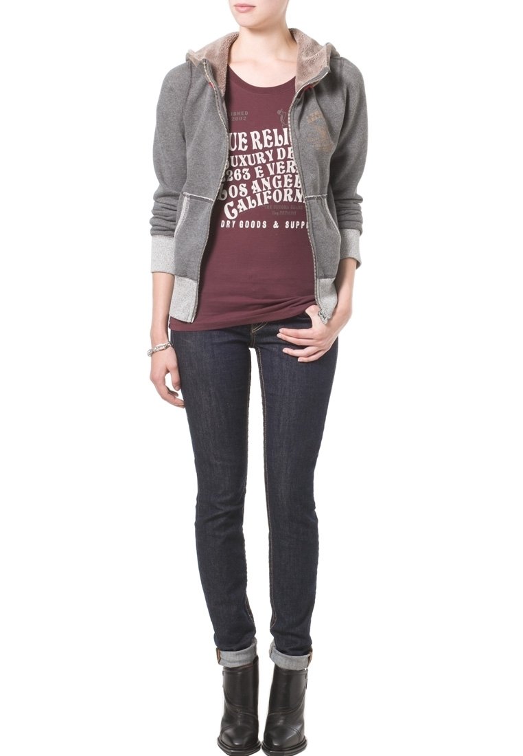 Grå zip-up hoodie med entexturerad insida, bourgogne grafisk t-shirt, mörkblå jeans och svarta ankelboots. Enkelt design, åtsittande form.