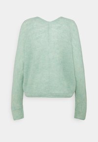 Mátově zelený pletený svetr s kulatým výstřihem, dlouhými rukávy a volným střihem. Textura je měkká s jemným melírovaným vzorem.