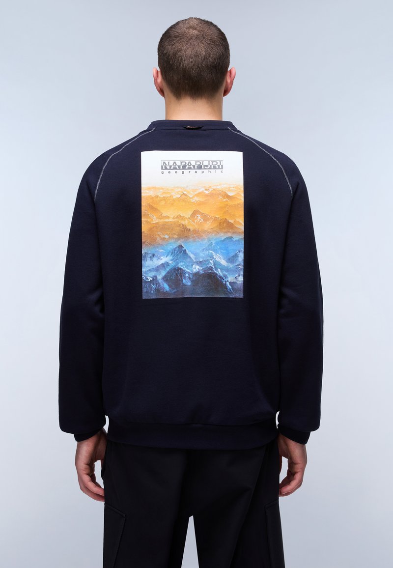 Felpa blu navy con una grafica rettangolare di montagne nei toni dell'arancione e del blu sul retro. Tessuto morbido, polsini e orlo a costine.
