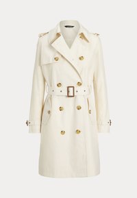 Double-breasted trench coat in cream fabric, featuring gold buttons, matching belt, and shoulder epaulettes. Long sleeves and side pockets.