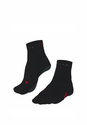 Een paar zwarte enkelsokken met grijze en rode accenten, met labels voor linker- en rechtervoet op de sokken.