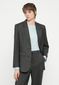 Sivý prúžkovaný blazer s prispôsobeným strihom, so zapínaním na klopu a dvoma prednými vreckami, skombinovaný s svetlomodrým rebrovaným topom.