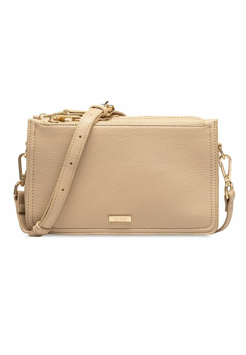 Beżowa skórzana torba na ramię z zamkiem błyskawicznym, złotymi detalami, regulowanym paskiem i teksturowaną powierzchnią. Wyposażona w dyskretną logotyp z przodu.