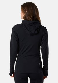Svart långärmad hoodie med en figurnära design, texturerad tyg och en avslappnad huva. Har tumhål och en diskret logotyp nära fållen.