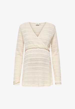 Haut de maternité crème à manches longues avec un décolleté en V et un design croisé, orné de motifs en dentelle horizontaux discrets.