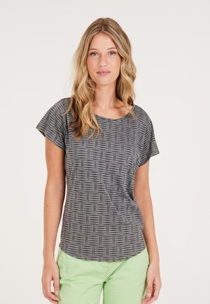 Top grigio a maniche corte con un motivo testurizzato di quadrati neri. Vestibilità leggermente ampia, scollatura rotonda, abbinato a pantaloni verde chiaro.