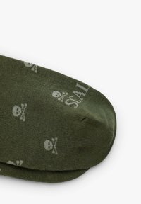 Sukat oliivinvihreitä, joissa on vaaleanharmaita pääkallokuvioita. Pehmeä materiaali, pyöreä varvasosa ja ribattu reunus. Sopii kaupunkimekkoihin.