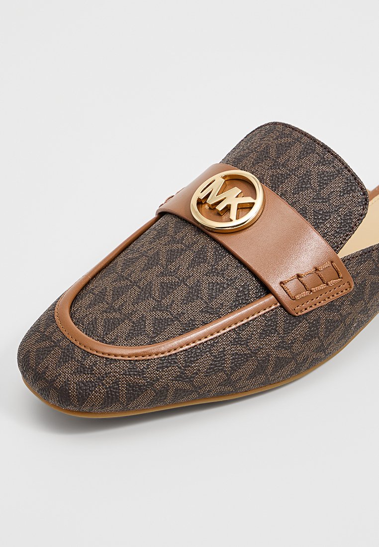 Bruine stoffen loafers met een gestructureerd patroon, voorzien van een tan leren band en een gouden logo-accent op de band. Plat zoolontwerp.