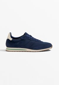 Tengeri kék, velúrból és sima anyagokból készült sneaker, világos színű sarok díszítéssel és diszkrét zöld talpcsíkkal.