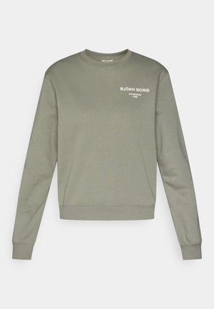 Olivno zelena bombažna jopica z dolgimi rokavi, okroglim izrezom in rebrastimi manšetami. Na prsih ima bel napis znamke.