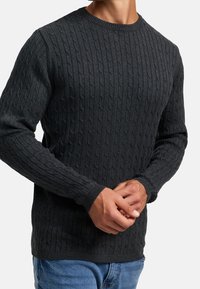 Mörkgrå kabelstickad tröja med rund halsringning och långa ärmar, med ett texturerat mönster och ribbade muddar.