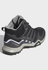 Chaussure de randonnée Adidas Terrex noire et grise avec label Gore-Tex, semelle robuste et col rembourré, vue de dos et de côté.
