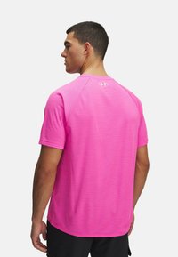Rosa Sport-T-Shirt aus strukturiertem Stoff, mit kurzen Ärmeln und rundem Hals. Verfügt über ein kleines Logo auf dem oberen Rücken.