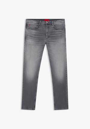 Jeans in denim grigio con vestibilità slim, caratterizzati da un design sbiadito, cinque tasche e un'etichetta con logo rossa sulla vita.