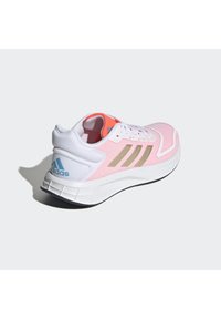 Scarpa sportiva rosa e bianca con tomaia in rete, tre strisce beige e logo azzurro. Presenta un collare imbottito e una suola testurizzata.