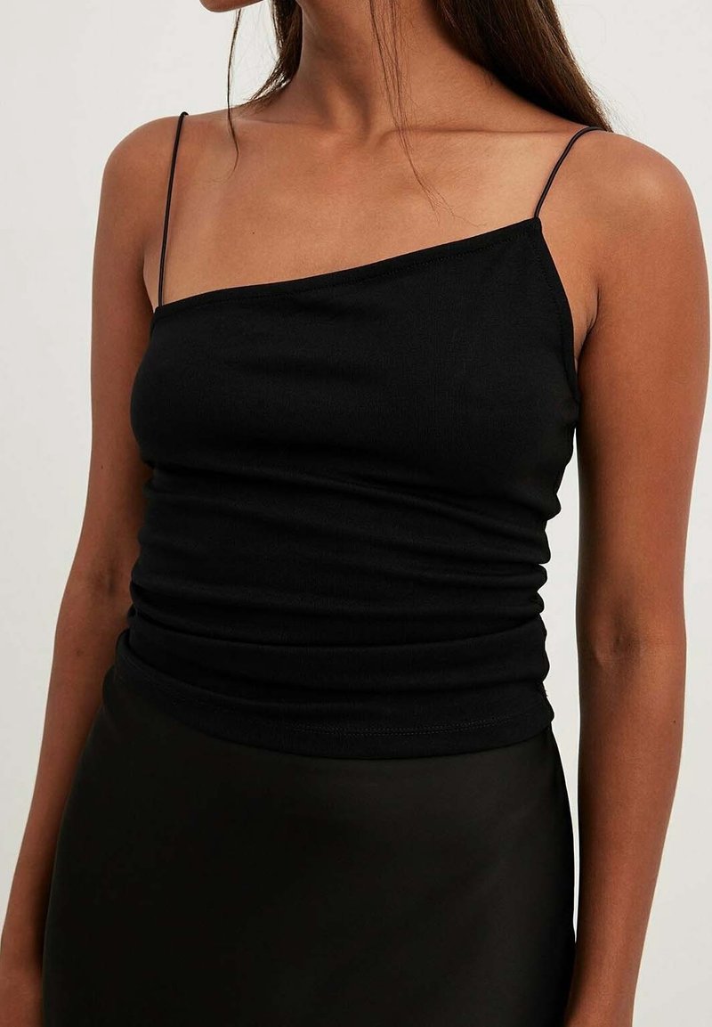 Černý tank top z pružného materiálu, s jedním odhaleným ramenem a přiléhavým střihem s nařasenou texturou v pase.