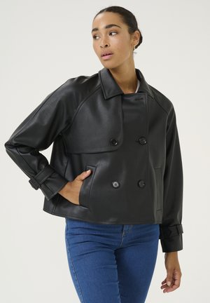 Black faux leather jacket with a double-breasted design, oversized collar, and button details. Features cuff straps and side pockets.