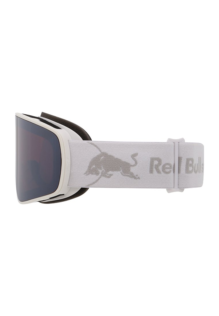 Lunettes de ski blanches avec lentilles teintées foncées et sangle grise ajustable portant un logo de taureau et le texte partiel "Red Bull".