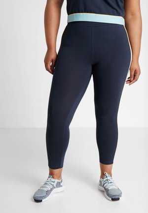 Leggings marinos con una cinturilla alta que presentan un acabado en azul claro. Hechos de un tejido elástico, ofrecen una silueta ajustada.