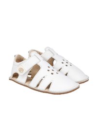 Las sandalias de piel blanca cuentan con detalles cortados, una puntera redondeada y una correa de Velcro para un ajuste seguro, con una suela de goma marrón claro.