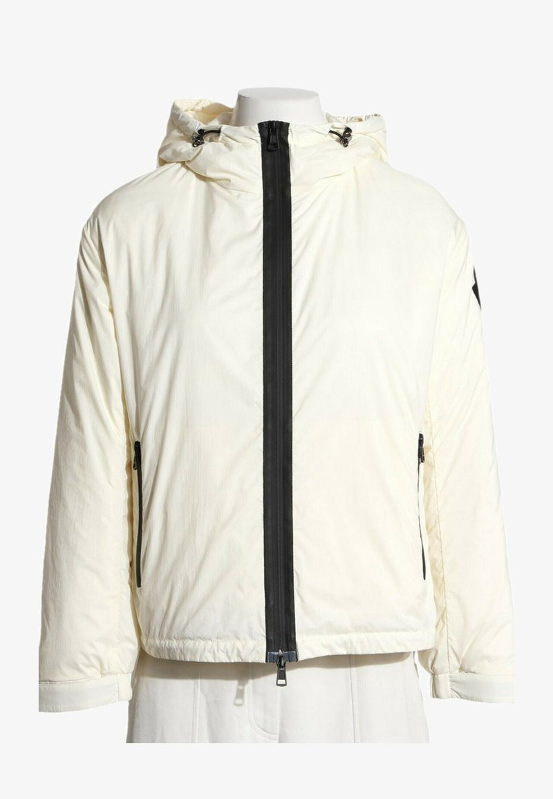 Veste blanche à capuche avec une fermeture éclair noire sur le devant et des poches latérales zippées noires sur un torse de mannequin.