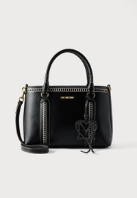 Μαύρη δερμάτινη τσάντα χειρός με αντιθετική λευκή ραφή, διπλές λαβές, αποσπώμενο ιμάντα ώμου και κρεμαστό ταμπελάκι με το λογότυπο "M".