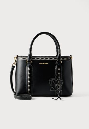 Fekete bőr kézitáska kontrasztos fehér varrással, dupla fogantyúval, levehető vállpánttal, és egy "M" betűs logófüggővel.