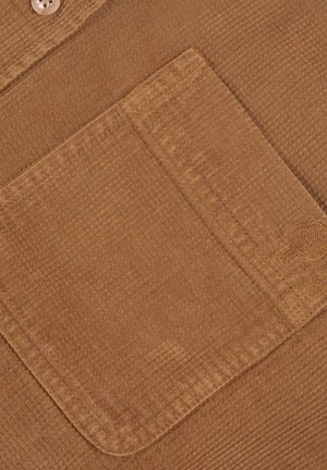 Braun strukturiertes Gewebe mit einer aufgesetzten Tasche. Verfügt über ein geripptes Design und eine verdeckte Knopfverschluss. Weiches Material mit einem subtilen Glanz.