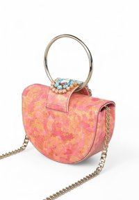 Bolso de mano con patrón rosa y dorado, con un asa de metal circular, solapa adornada y una correa de cadena, que presenta una textura suave y una forma estructurada.