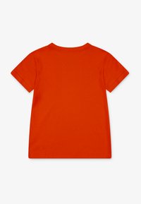 Kortærmet T-shirt med rund hals i lys orange, lavet af blødt bomuld. Har et enkelt design med færdige kanter og ingen mønstre.