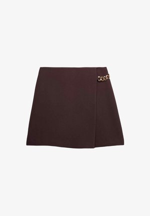 Mini-jupe marron foncé à design asymétrique avec un nouage sur le côté, ornée d'un petit détail en chaîne dorée sur le côté droit.