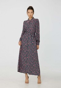 Robe à manches longues avec boutons, à motif foncé orné de fleurs roses. Tissu doux avec un col chemise et une ceinture à la taille.