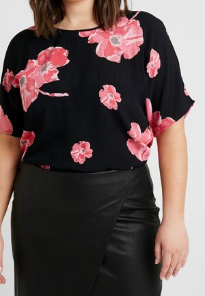 Czarny top z różowym kwiatowym wzorem; luźny krój, krótkie rękawy; zestawiony z czarną spódnicą owijaną ze sztucznej skóry; gładka faktura.