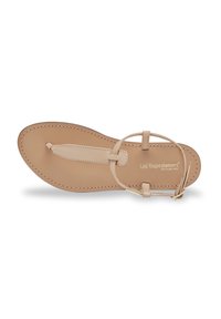 Beige flade sandal med en tåsløjfe og ankelrem, lavet af glat læder. Har syninger og et minimalistisk design.
