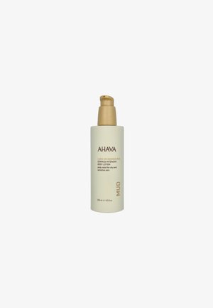 AHAVA Dermud Intensive Body Lotion in einer hohen, matten weißen Flasche mit einer goldenen Pumpe, gekennzeichnet für die Linderung von trockener und empfindlicher Haut, 250 ml.