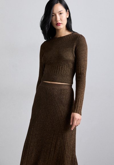 Brown ribbed knit crop top and long skirt set, featuring horizontal and vertical patterns, round neckline, and fitted silhouette.