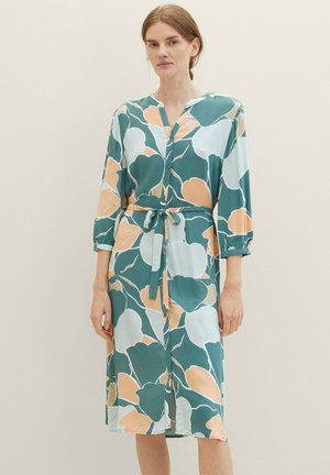 Jersey-Midikleid mit grünem, weißem und pfirsichfarbenem Blumenmuster, Notch-Kragen, Knopfleiste und Taillengürtel. Lange Ärmel mit hochgerollten Manschetten.