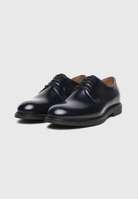 Navy leather dress shoes with a polished finish, round toe, and black rubber sole; features lace-up design and minimal stitching details.
