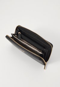 Portafoglio in pelle nera con zip e dettagli in tono oro. Presenta più scomparti, slot per carte e una fodera interna a motivi.
